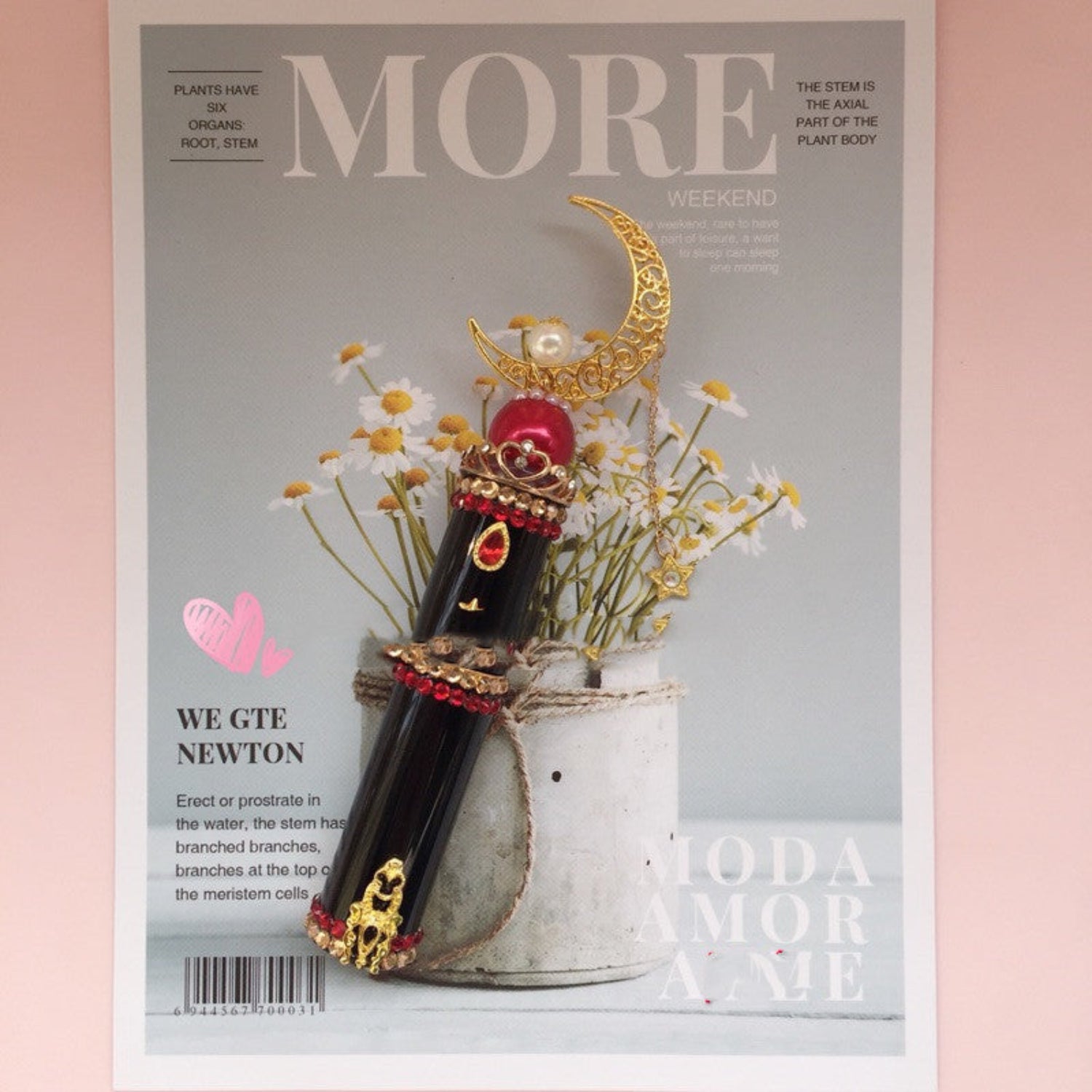 Black perfume bottle on magazine on pink background