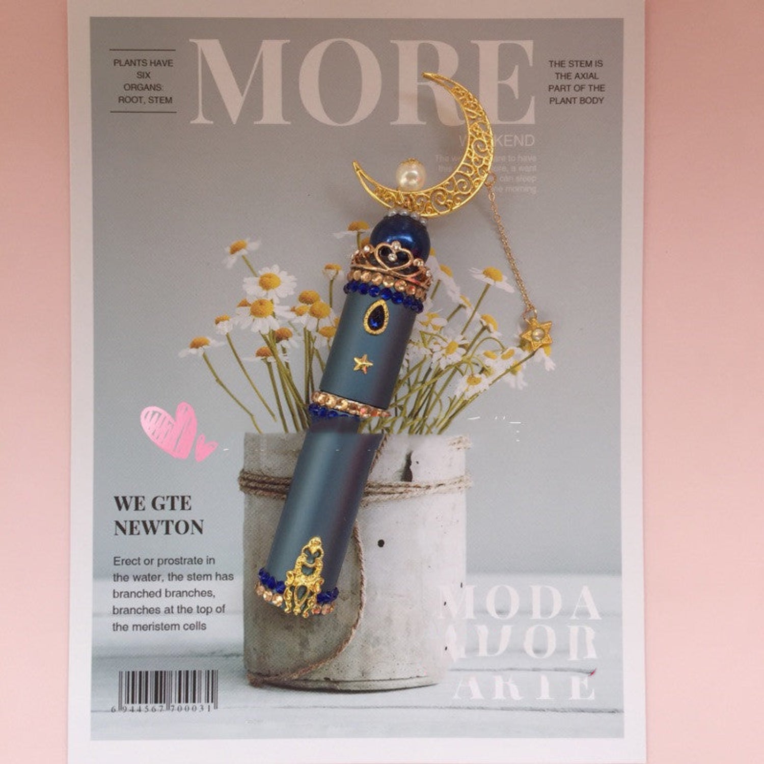 blue perfume bottle on magazine on a pink background
