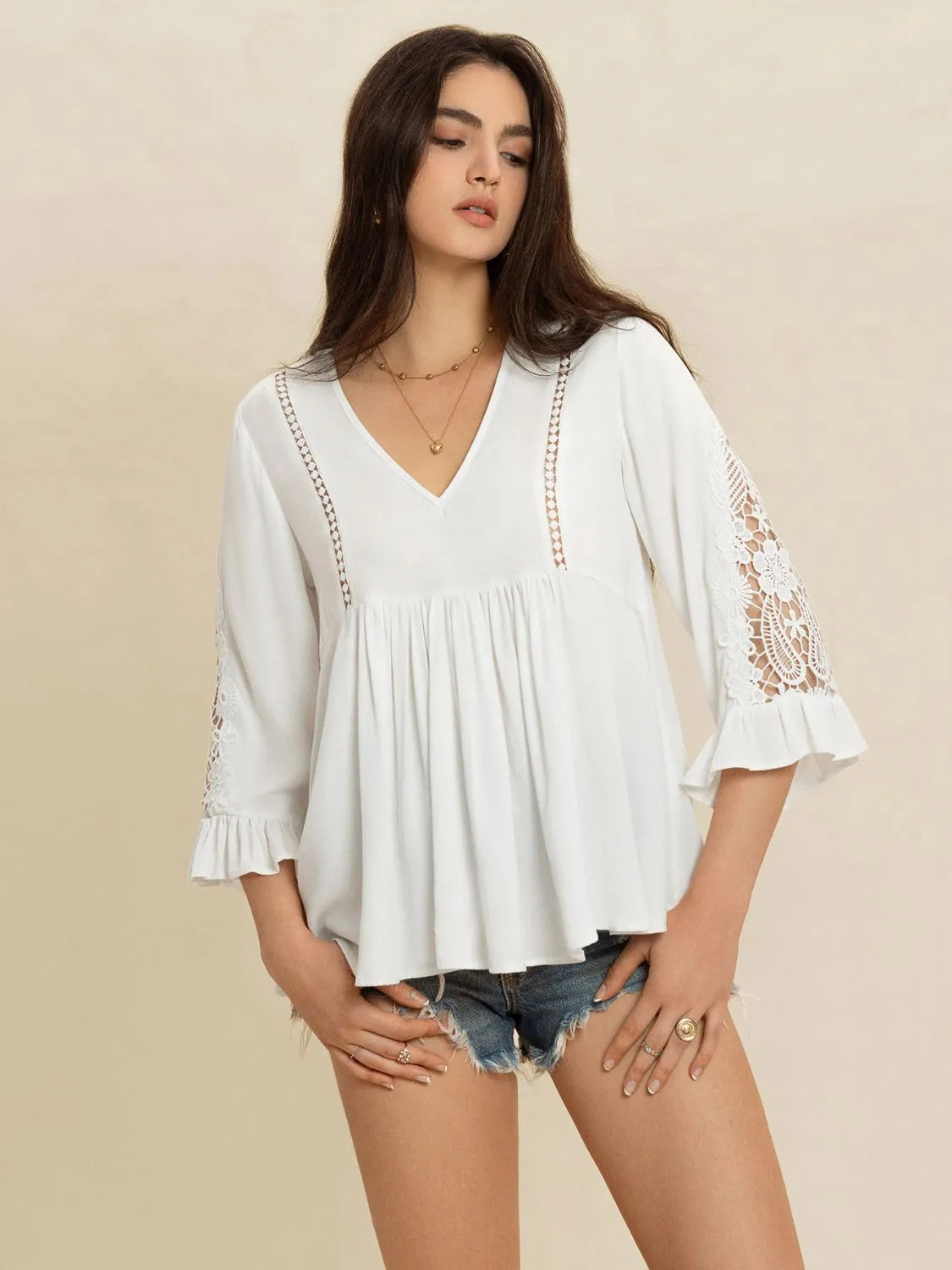 Model wearing the white Enchanted Lace Flounce Sleeve V‑Neck Top showing full front view with lace details and flounce sleeves.