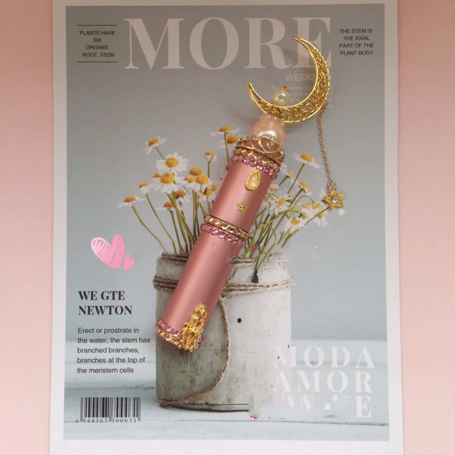 Pink Perfume bottle on a magazine on a pink background
