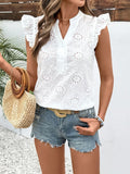 Woman wearing a white eyelet top and denim shorts, holding a straw bag.