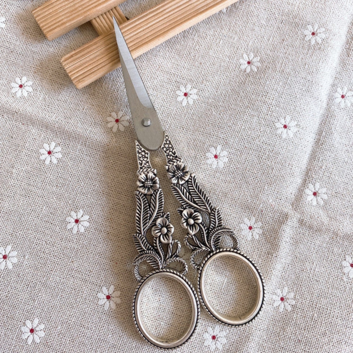 silver scissors on white flower background