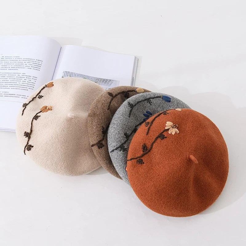 4 multi colored berets sitting on a white background