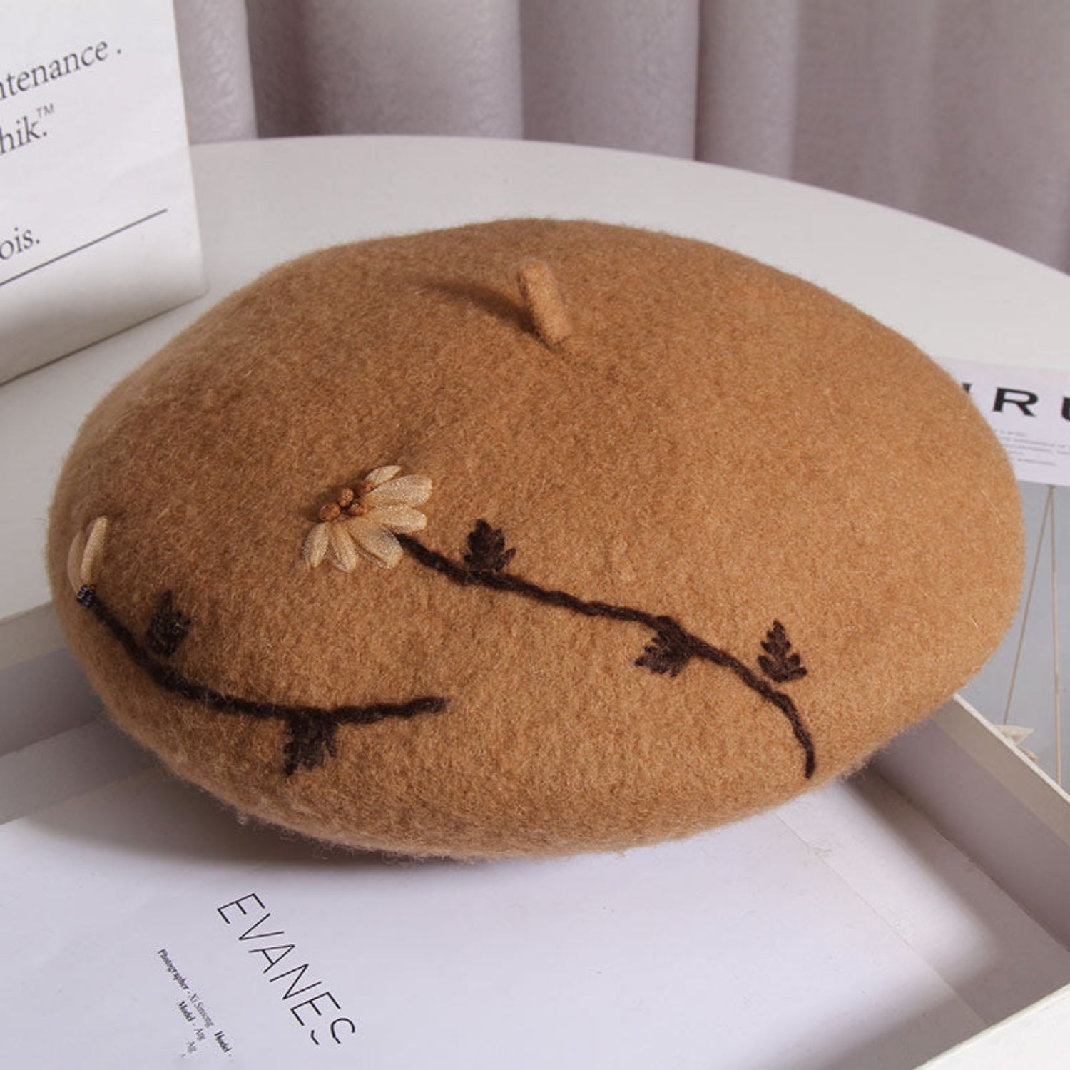 honey brown daisy embroidered cap sitting on a white table