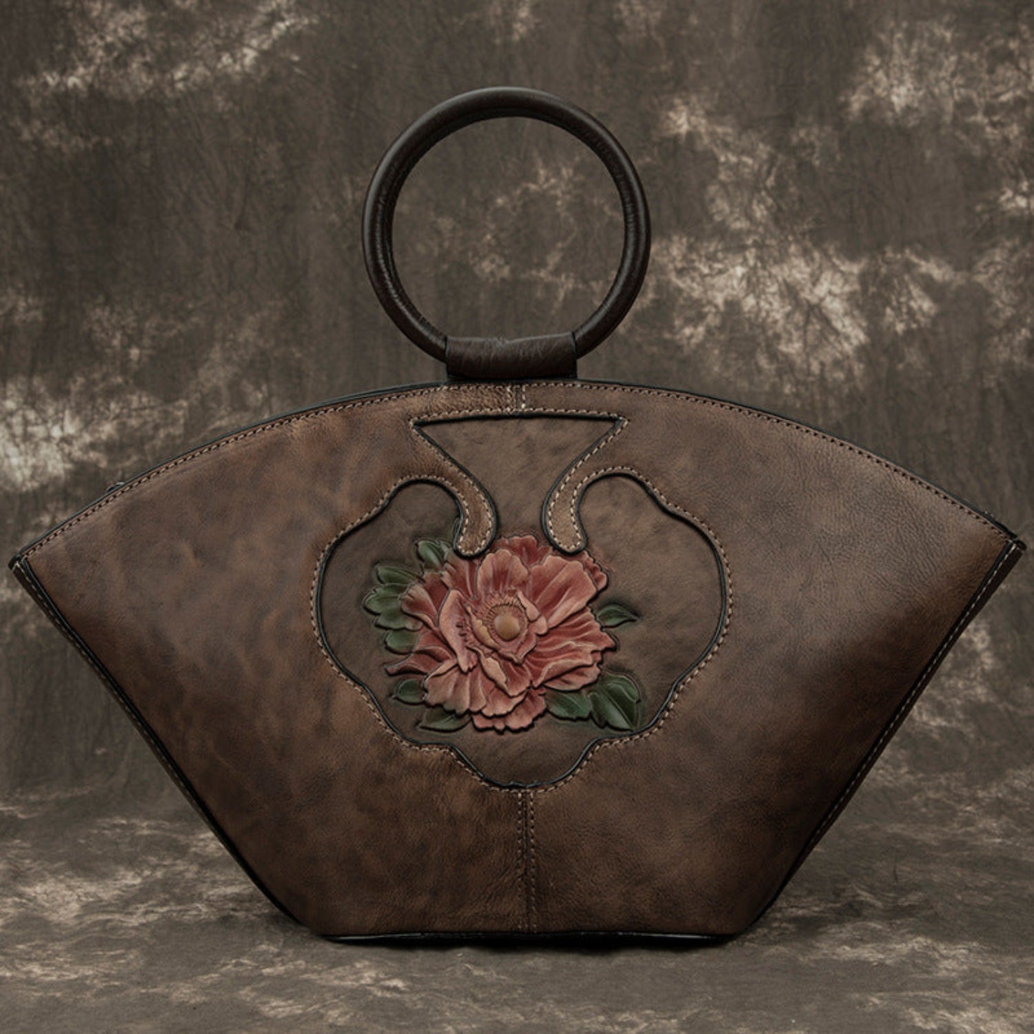 front view Vintage‑style leather Boston bag with an embossed flower inside a bottle‑shaped motif