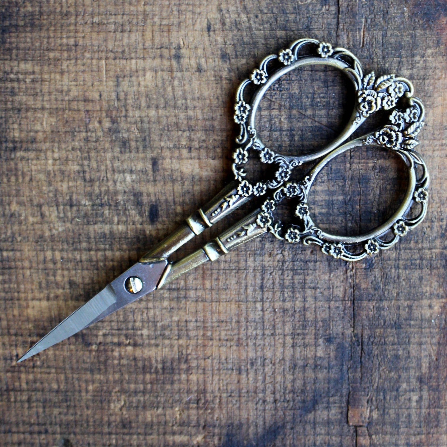 Decorative silver scissors on a wooden surface