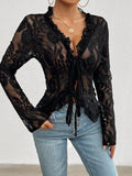 Black lace top worn by a person with a plain background