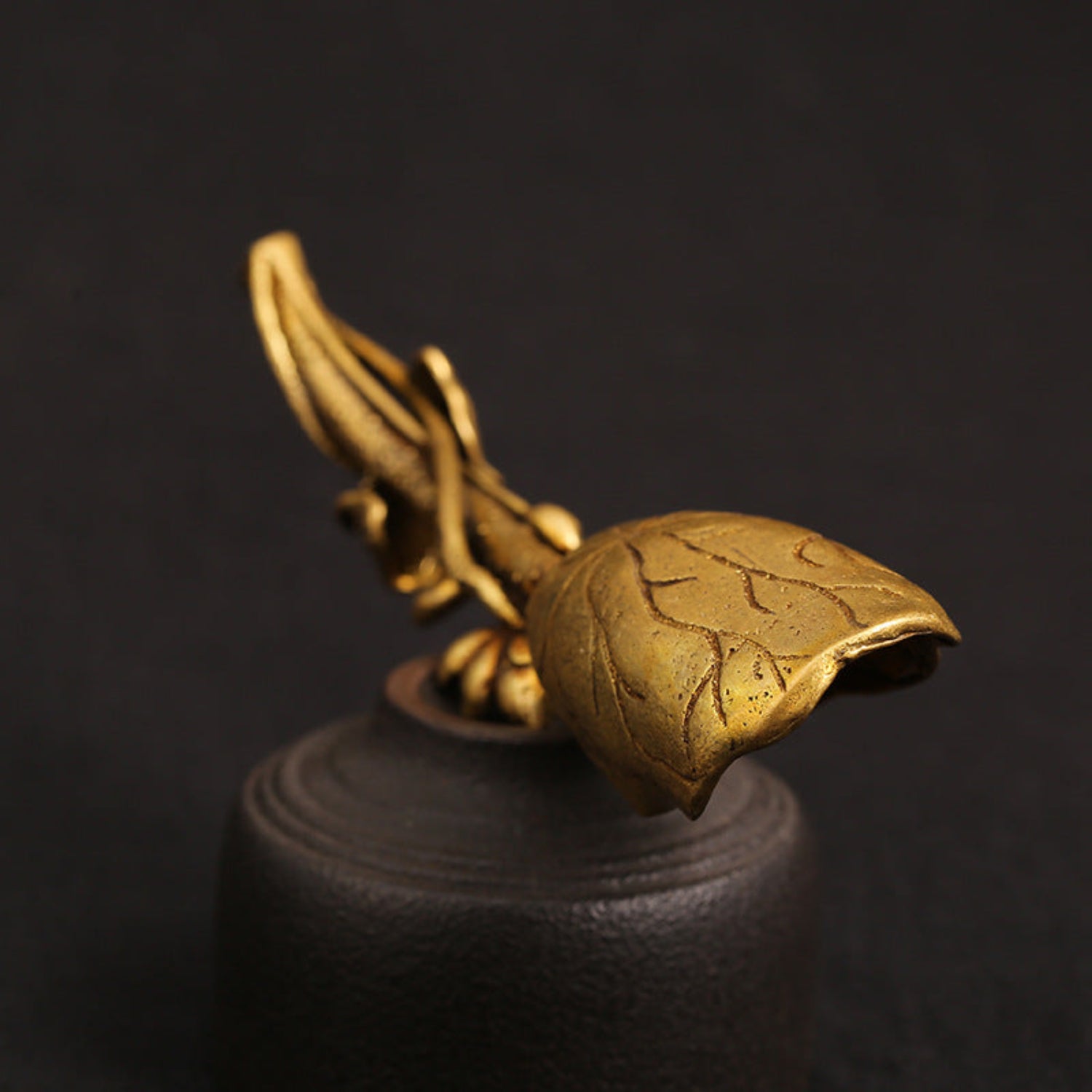bottom view close up Pure brass lotus leaf tea shovel with a sculpted lotus flower and leaf‑shaped scoop, shown in a golden antique finish