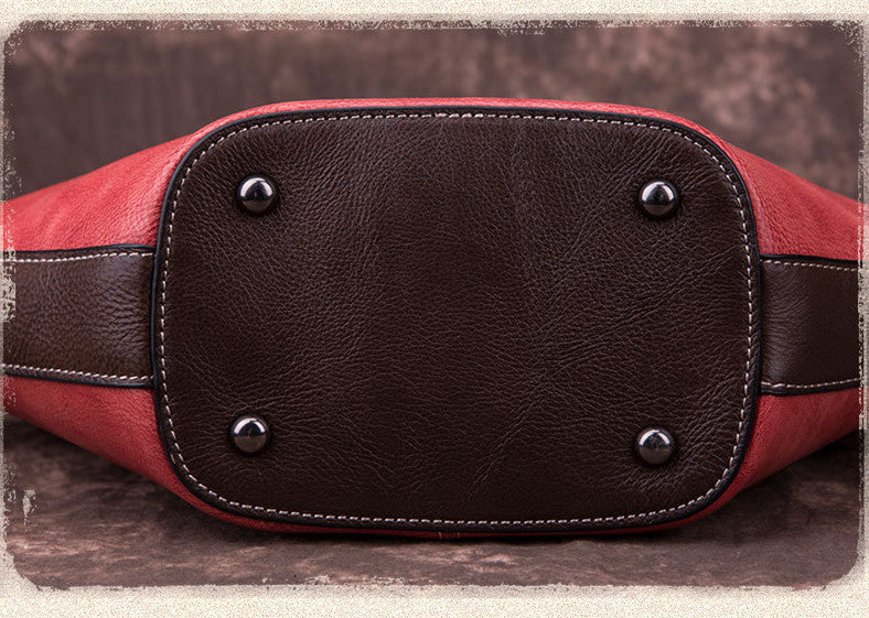 bottom view of Vintage‑style leather Boston bag with an embossed flower inside a bottle‑shaped motif