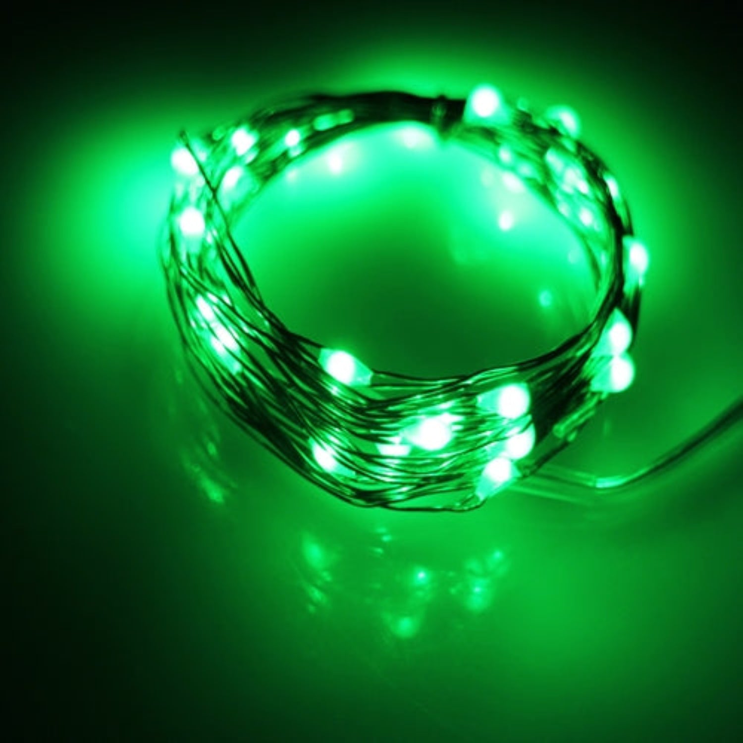Green LED string light coiled on a dark green background