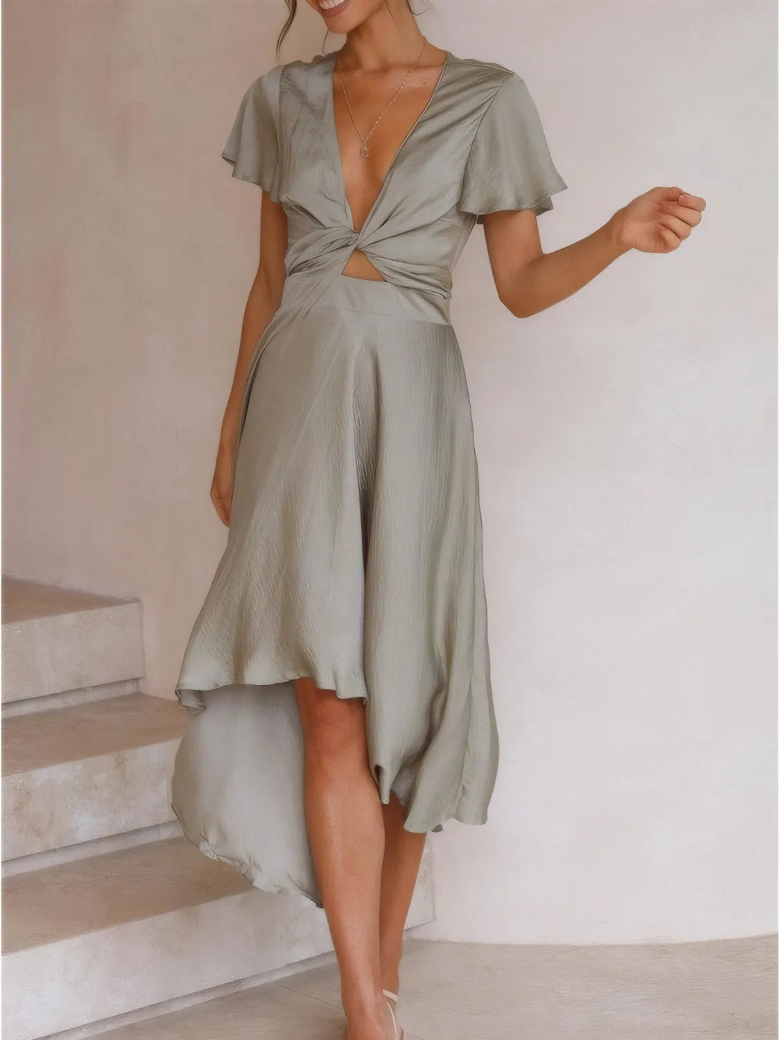 Model wearing the sage high‑low plunge dress from the front, showing the flutter sleeves and lightweight fabric.