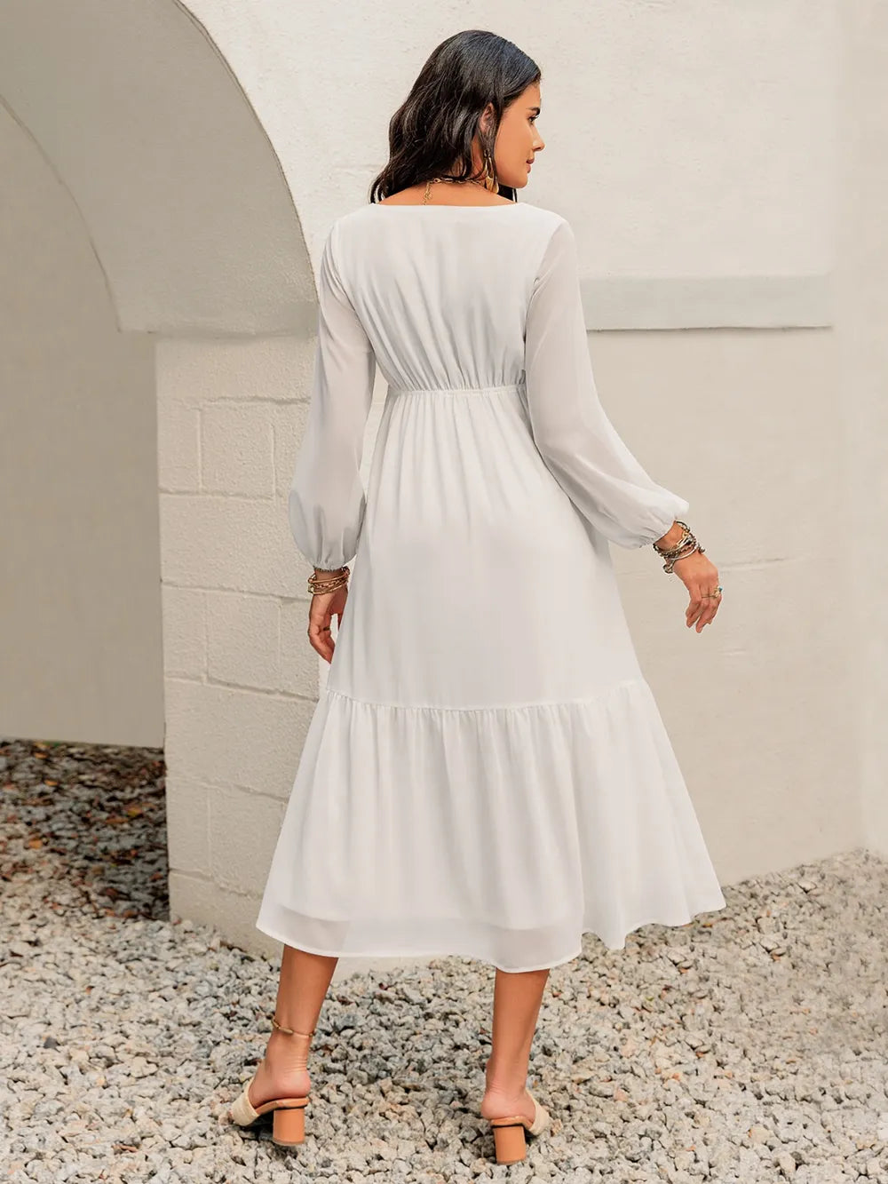 Back view of the printed square‑neck balloon sleeve dress on the model, showing the smooth lined back and soft fabric.