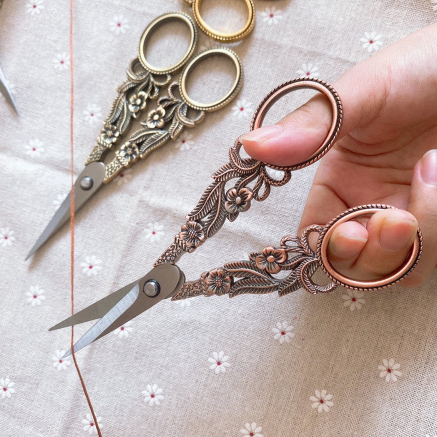 2 pairs scissors on white flower background