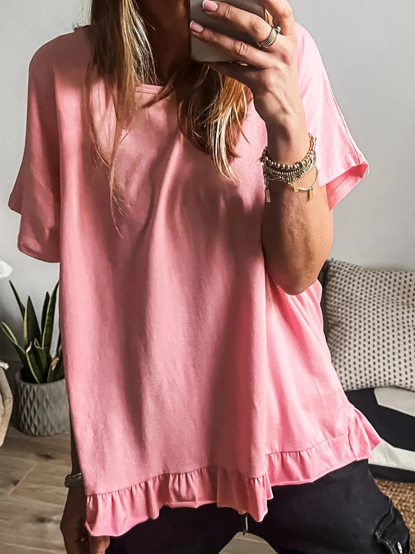 Front view of the pale blush ruffle hem round‑neck relaxed T‑shirt on a model.