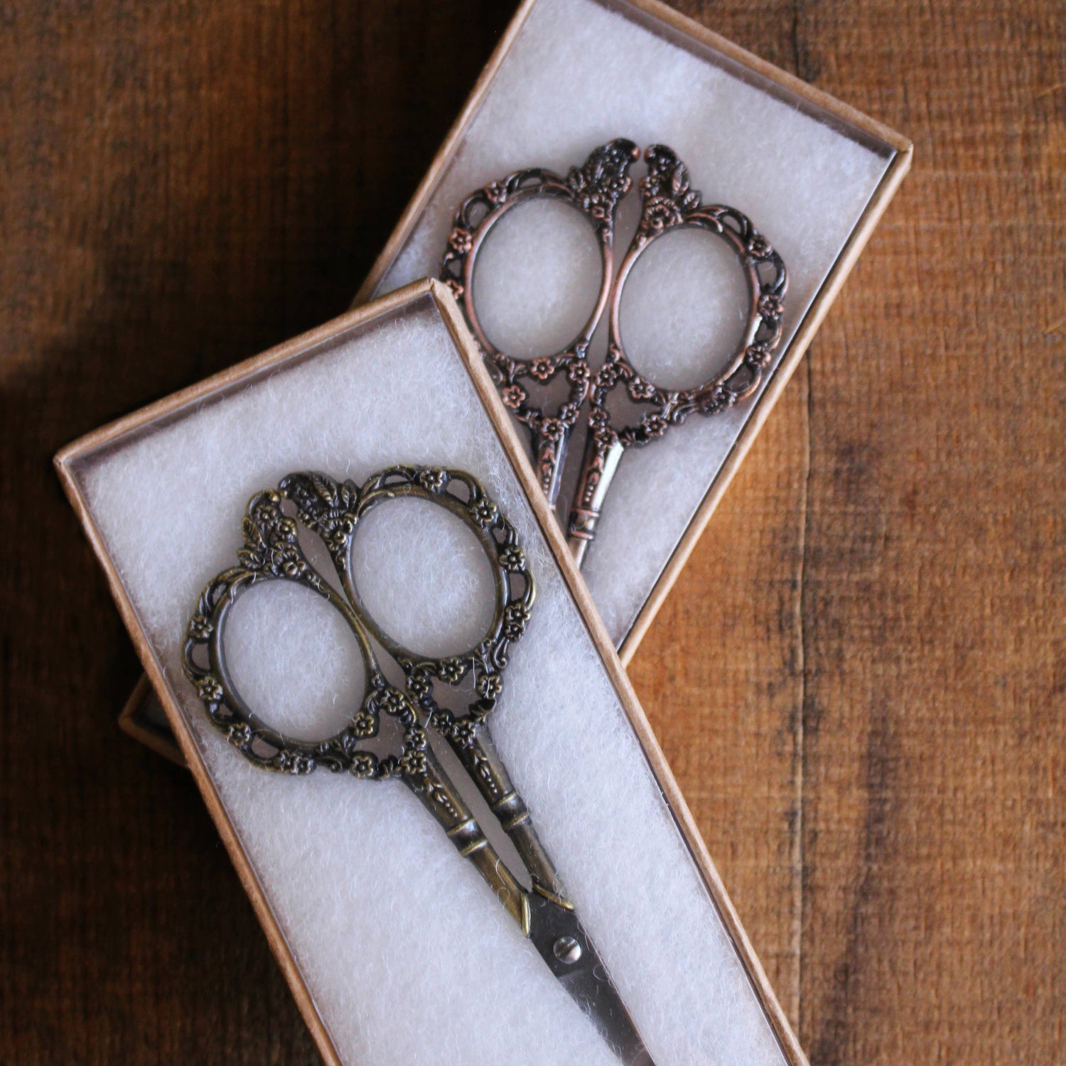 Pair of ornate scissors in a box on a wooden surface