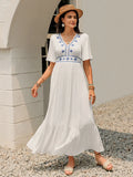 Model wearing the White Briar Cottage Dress from the front, showing the flutter sleeves and ruffled hem.
