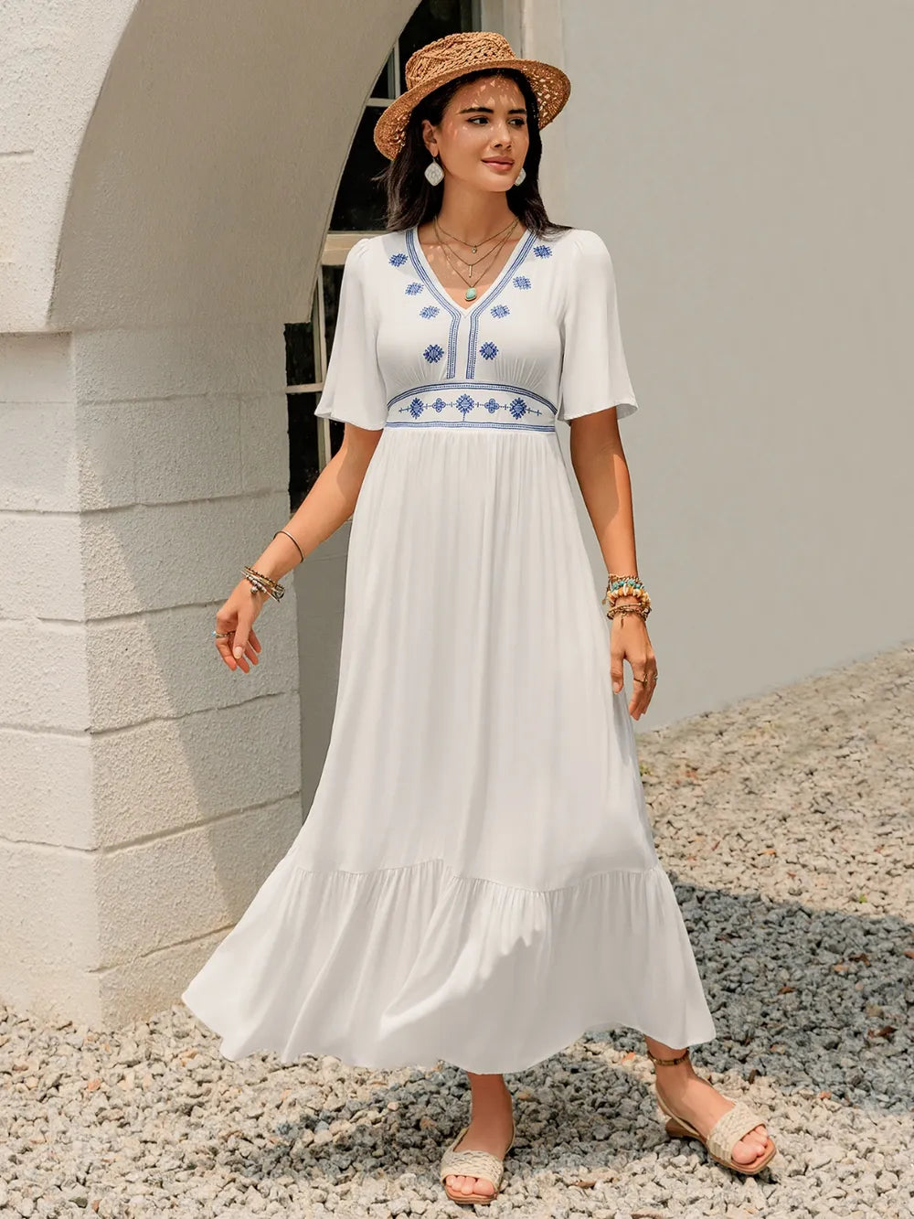 Model wearing the White Briar Cottage Dress from the front, showing the flutter sleeves and ruffled hem.