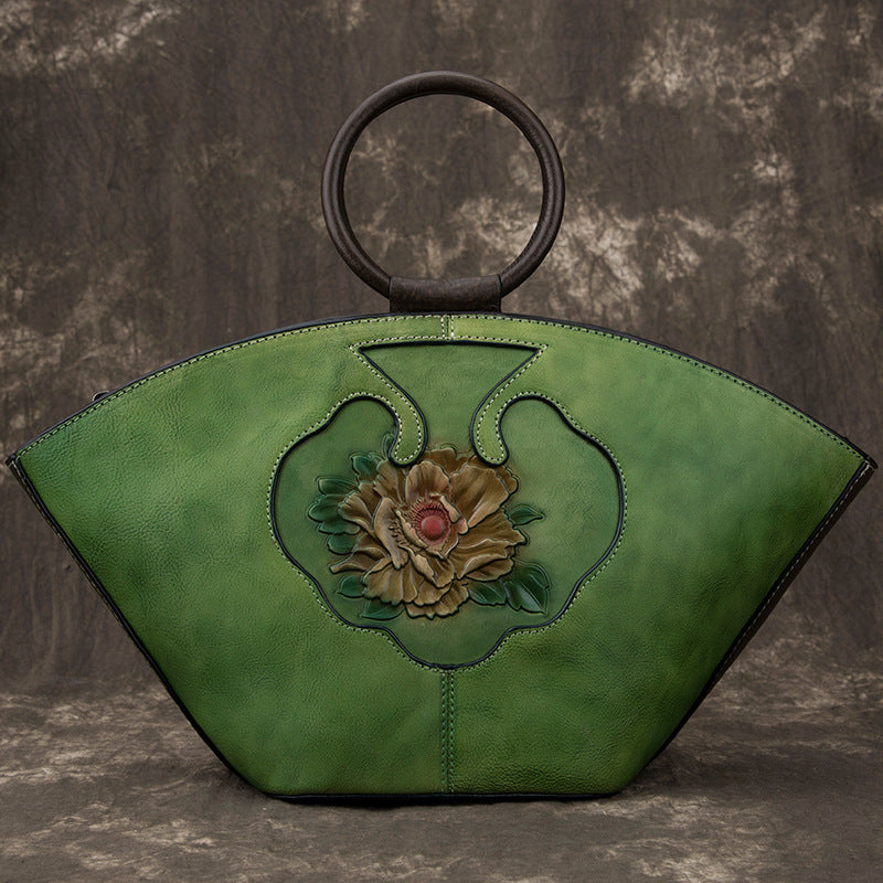 Woodland green Vintage‑style leather Boston bag with an embossed flower inside a bottle‑shaped motif.